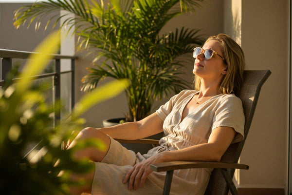 Mulher relaxando em uma varanda com plantas ao fundo